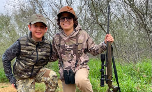 Group of four people enjoying a sunset over rolling hills, capturing the camaraderie at El Estribo Ranch.